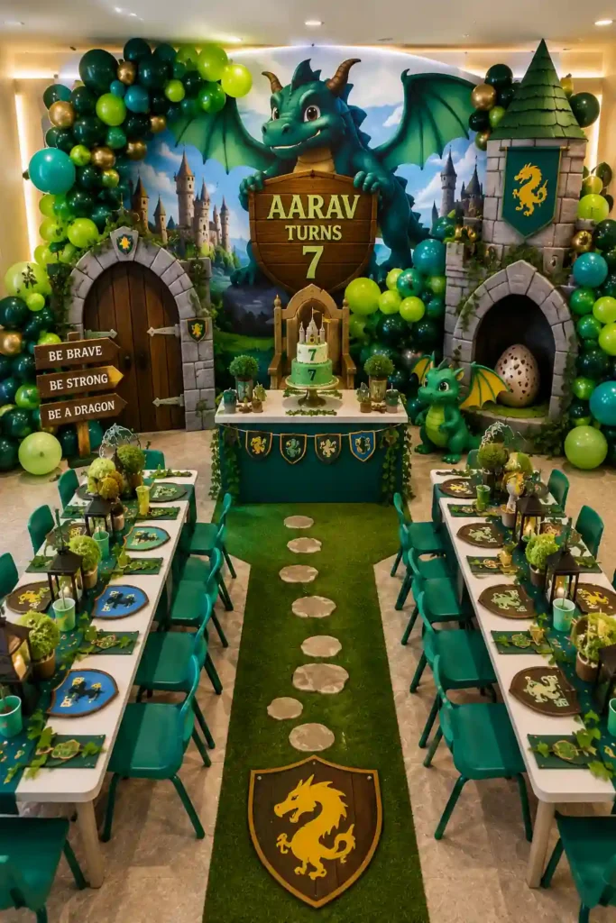 Fantasy dragon-themed birthday party setup featuring a large friendly dragon backdrop, castle towers, medieval-inspired décor, and green, teal, and gold balloon garlands. A personalized sign reads 'Aarav Turns 7,' while a dragon-themed cake, shields, banners, lanterns, and a dragon egg prop enhance the magical setting. Children's banquet tables and a grassy pathway create an immersive kingdom adventure atmosphere